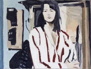 Portrait der Schauspielerin Sophie Marceau in einem gestreiften Hemd. Im Hintergrund ein Fenster und Hauseingang